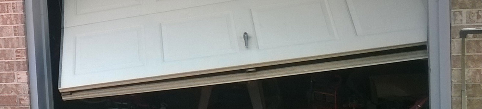 Close-up of damaged garage door panel and misaligned position in Cypress, CA